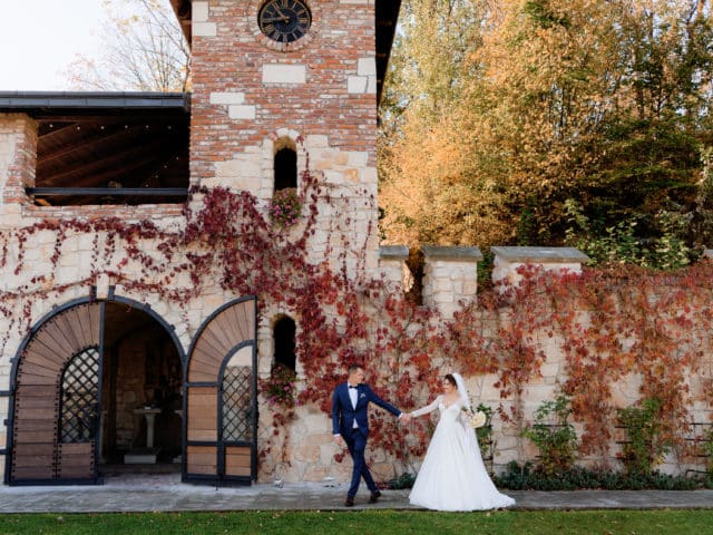 happy groom and bride are holding hands together and walking in